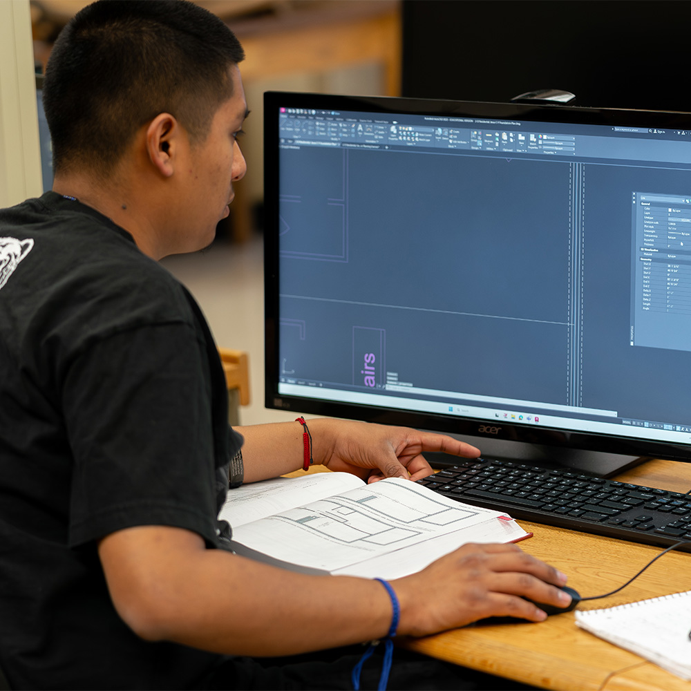 An engineering student working with CAD software