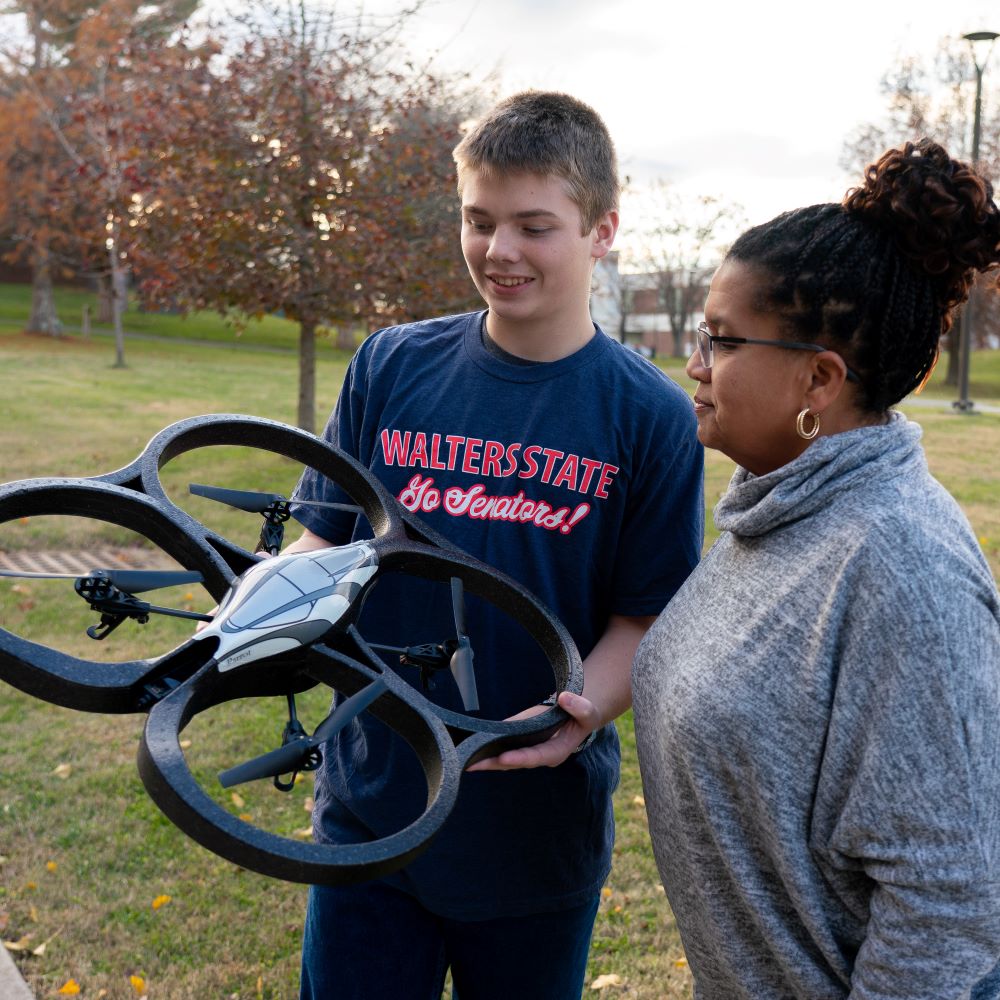 People working with a drone.